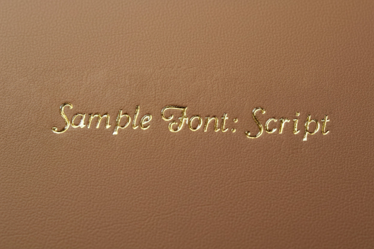 Gold script embroidery initials sample font on brown fabric background