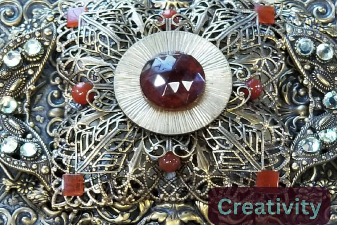 Close-up of ornate jeweled metalwork with red gemstone and intricate gold filigree design