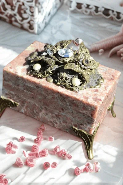 Handcrafted marble keepsake box with ornate jeweled brass accents on decorative legs
