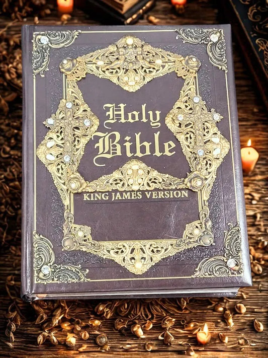 Handcrafted jeweled King James Bible with ornate gold detailing, surrounded by candles.