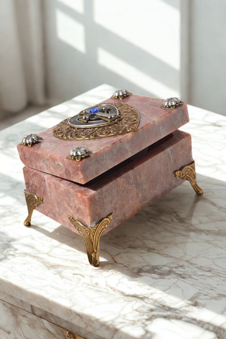 Pink marble jewelry box with gold feet and blue gem clasp, elegant keepsake for faith-based gifts