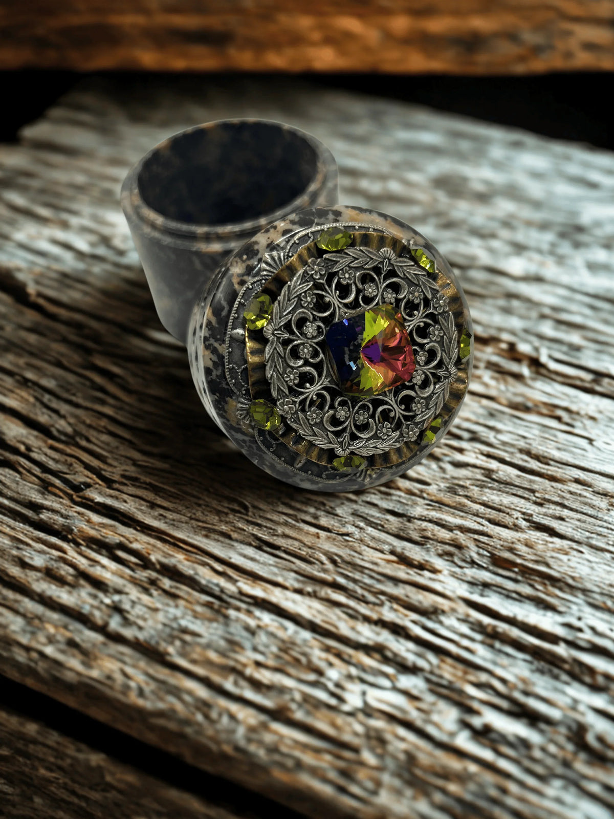Handcrafted soapstone keepsake box open, inside visible, ornate jeweled lid on rustic wood