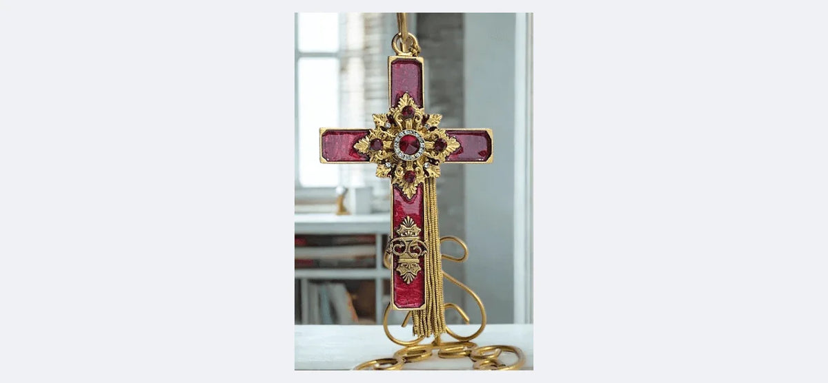 Vintage jeweled cross ornament with red gemstones and gold detailing on gold chain