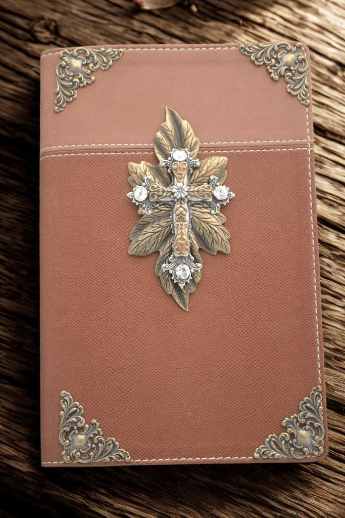 Jeweled brown Bible with ornate gold cross and decorative metal corners on wood background