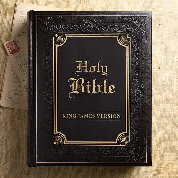 Dark brown faux leather King James Bible with gold embossed cover and ornate border, closeup
