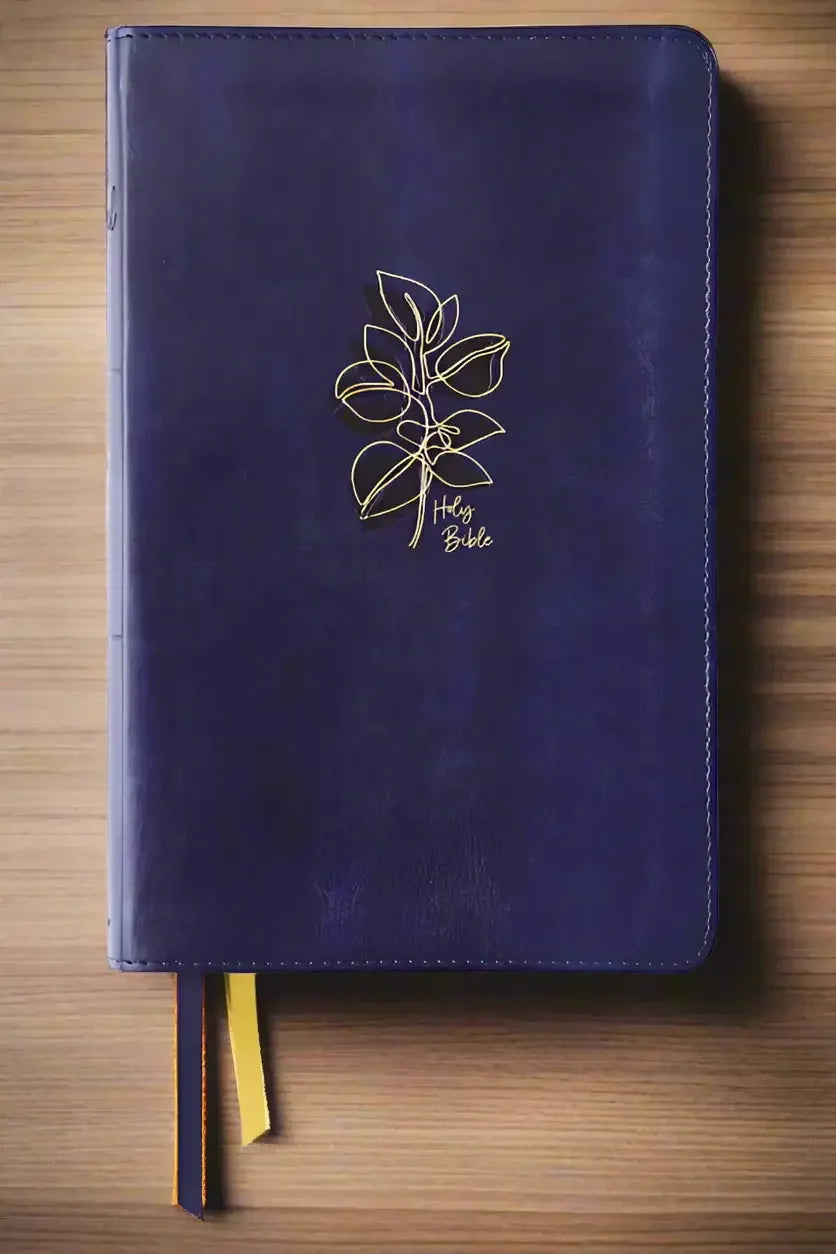Navy leather devotional Bible with gold leaf design and ribbon bookmarks, flat lay