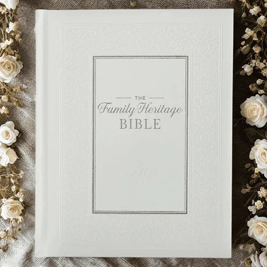 White hardcover Family Heritage Bible surrounded by cream flowers on textured fabric.