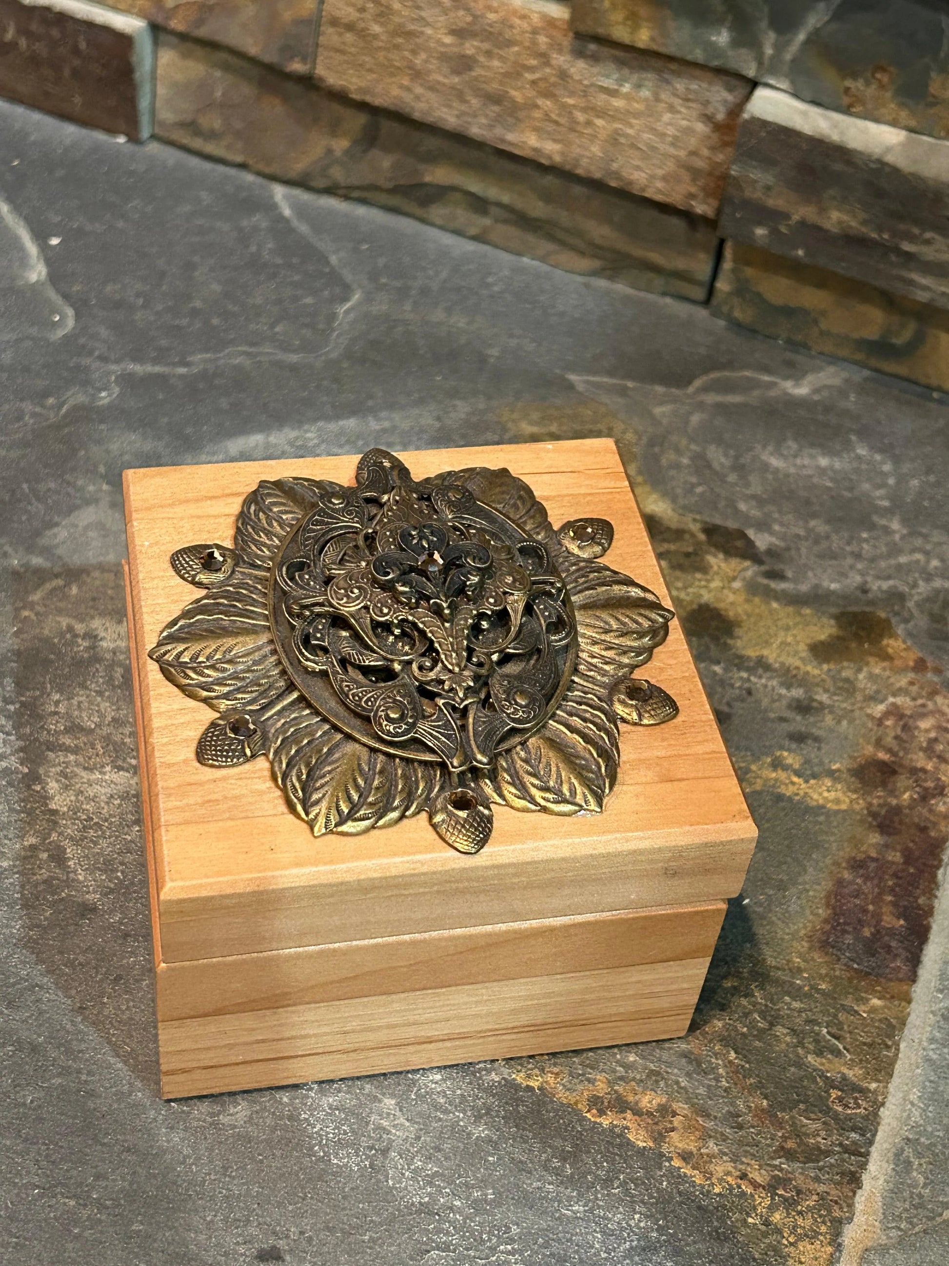 French-inspired wooden keepsake box with ornate metal floral embellishment, top view