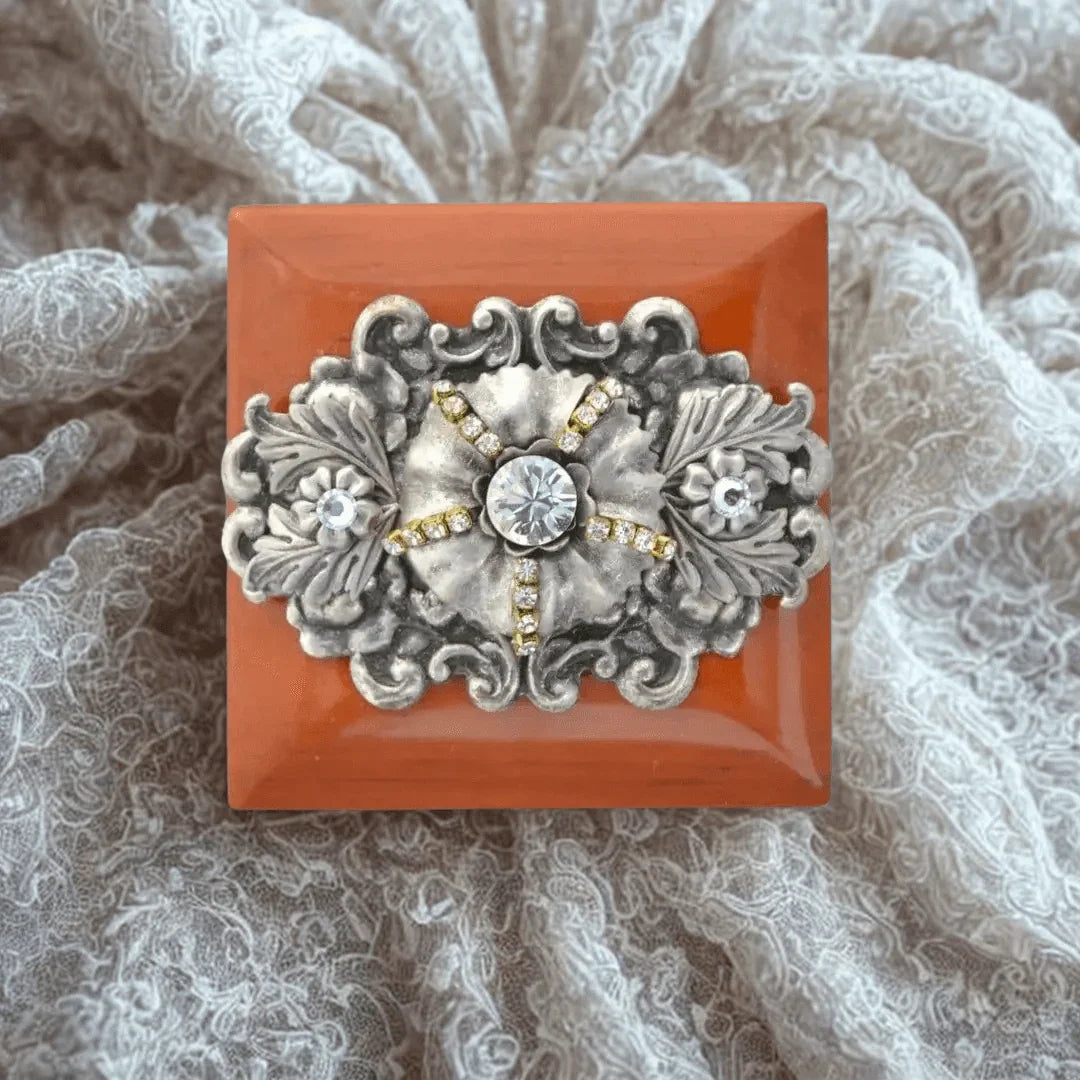 Handcrafted wooden ring box with ornate silver and gemstone detail on lace background