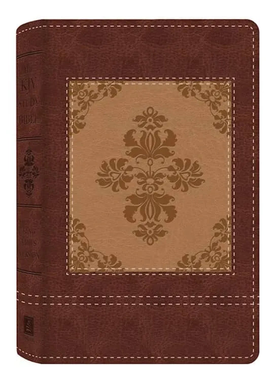 Close-up of a KJV study Bible bound in brown vegan leather with an ornate cross design on the cover.
