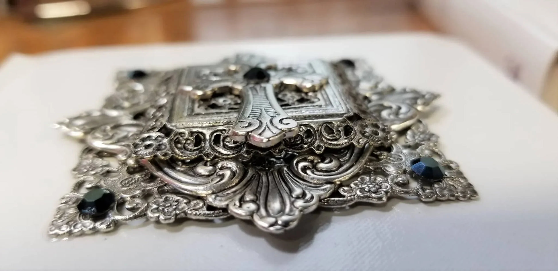 Close-up of ornate metal jeweled cross with gemstones on keepsake Bible cover