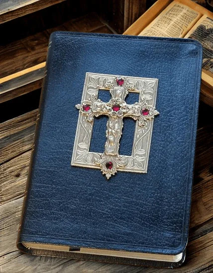 Black leather Bible with ornate jeweled silver cross cover on vintage wooden surface
