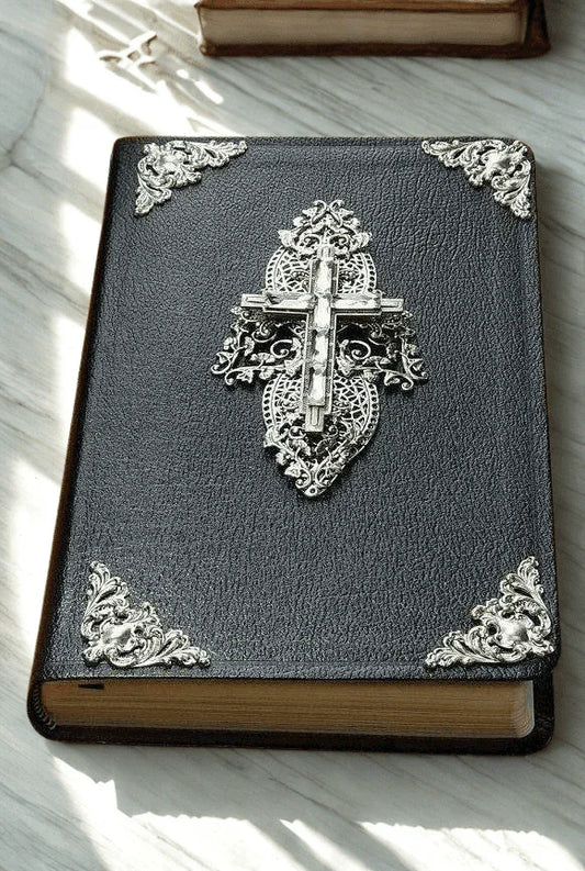 Jeweled Bible with black cover, ornate silver metal cross and decorative metal corners