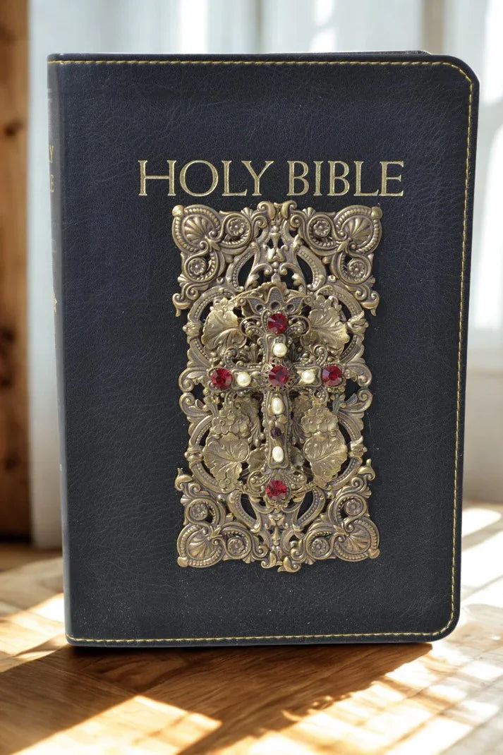 Jeweled Holy Bible with ornate gold cross and red gemstones on black leather cover