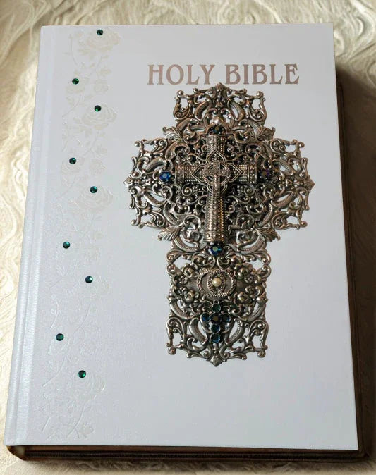 Jeweled white Holy Bible with ornate silver cross and blue gemstone accents
