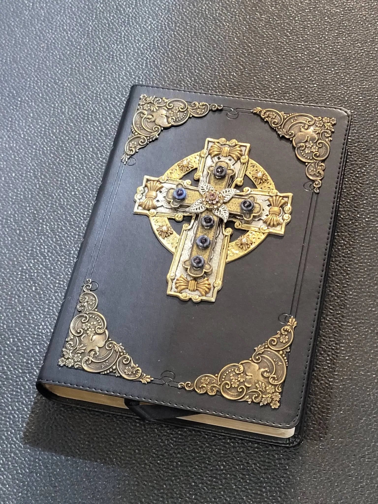 Black Bible with jeweled Celtic cross and ornate gold decorative corners on cover