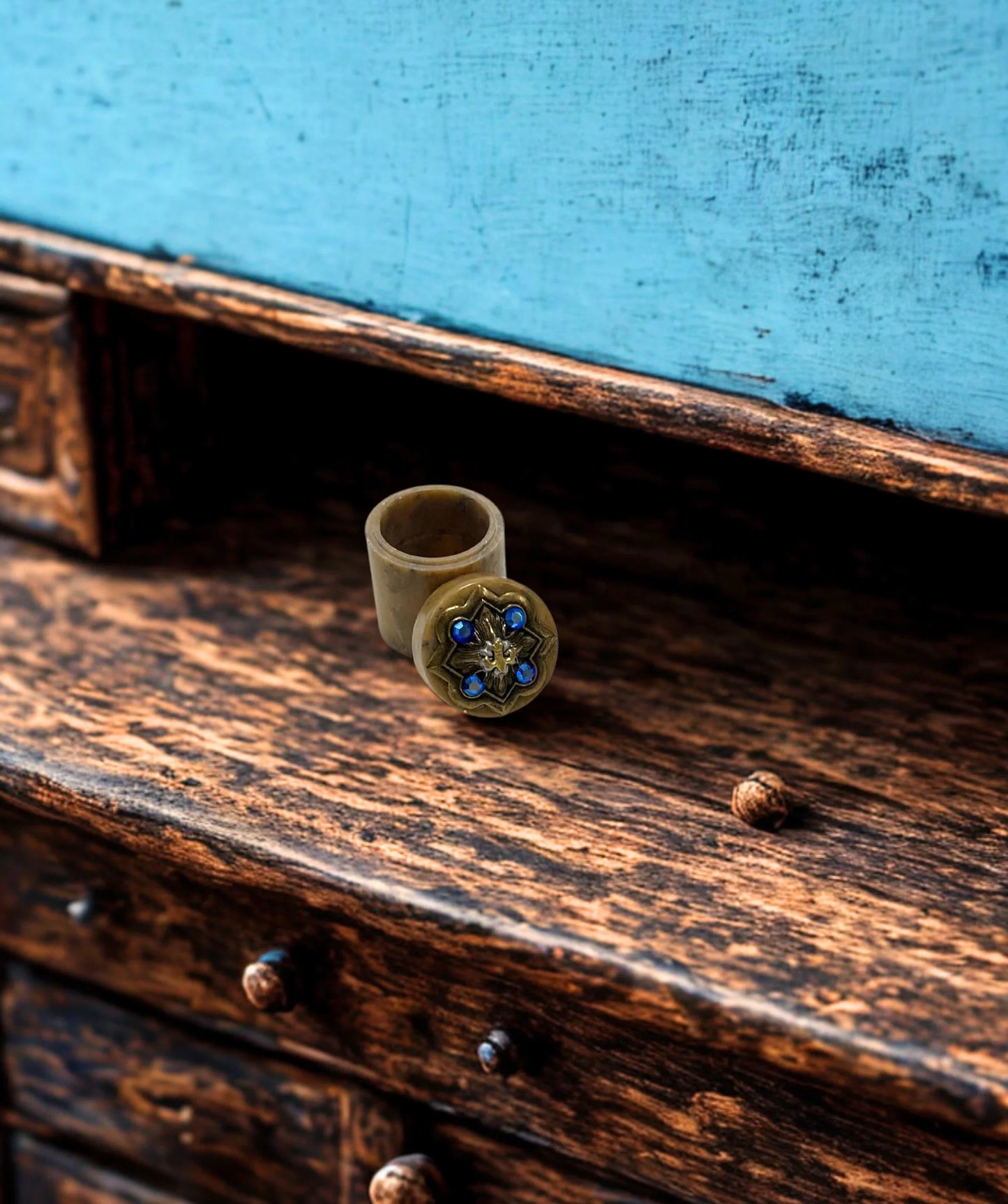 Jeweled fleur-de-lis trinket box open on rustic wooden surface