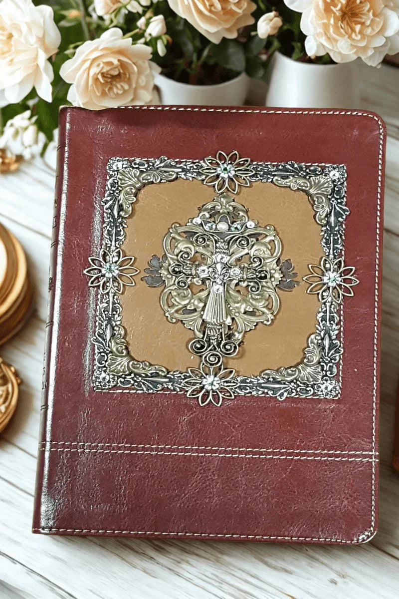 Jeweled KJV Bible with floral cross, ornate leather cover, on light wood with roses