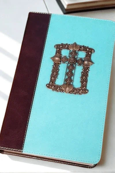 Jeweled teal leather Bible with ornate bronze cross design, giant print, on white background.