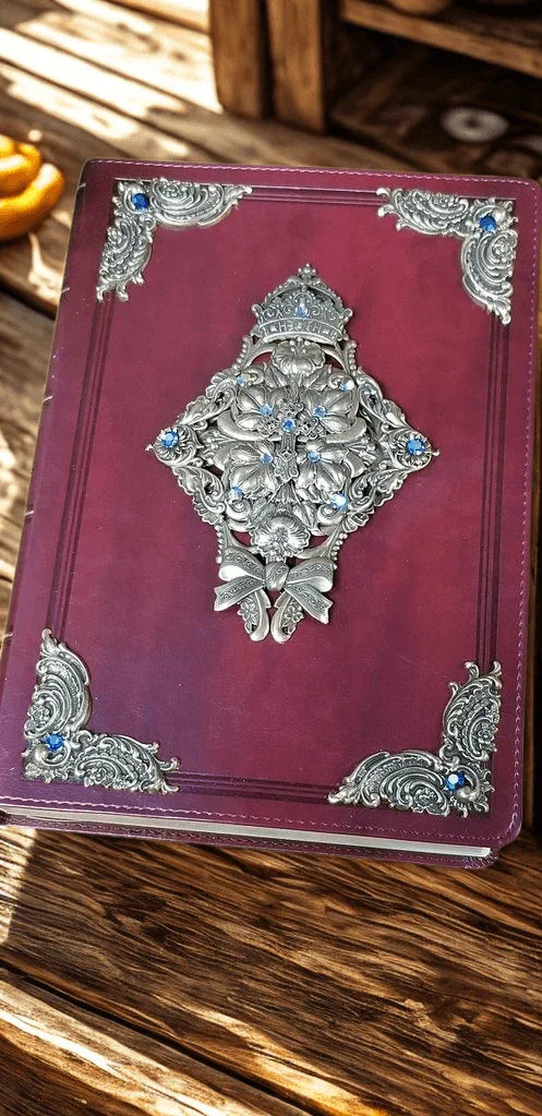 Jeweled King James Bible with ornate silver and blue embellishments on a wooden table.