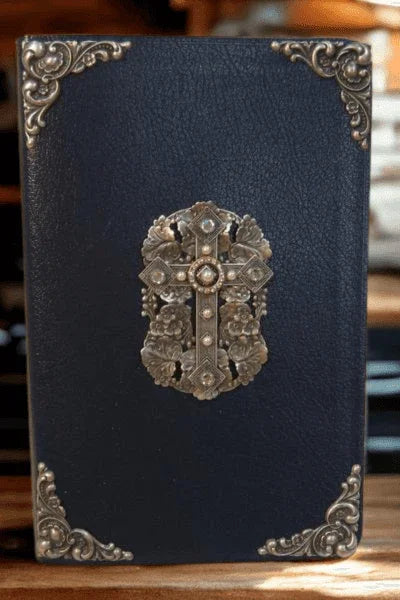 Jeweled NIV Bible with rhinestone cross, black cover, gold ornate accents, on wood background
