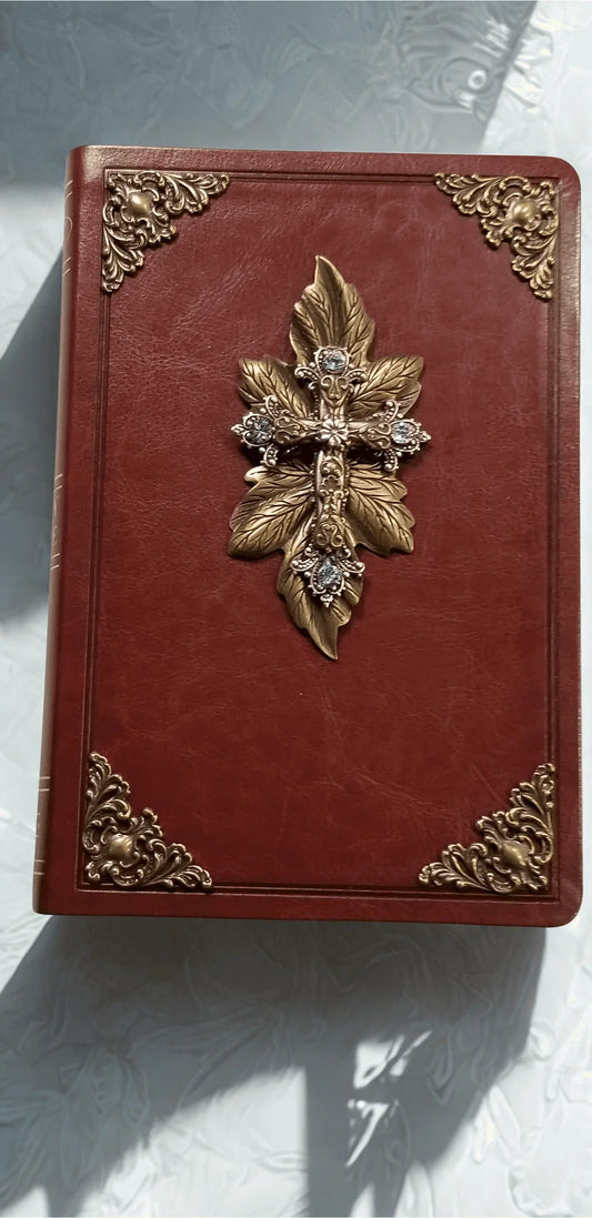 Closeup of a jeweled NKJV Bible with gold leaf cross and ornate metal embellishments