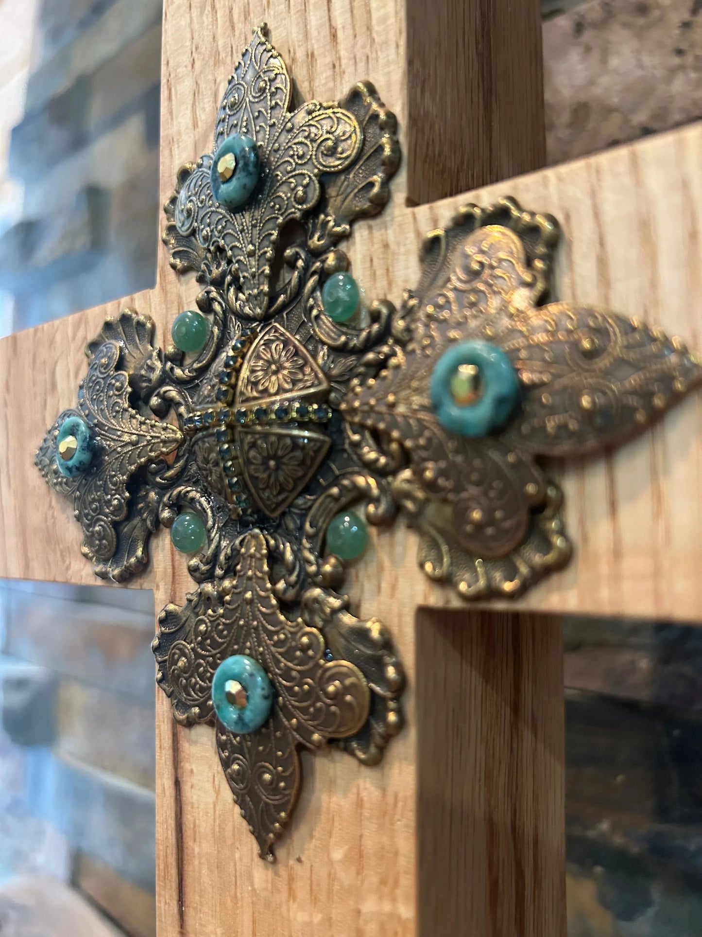 Closeup of jeweled oak cross with ornate metal filigree and turquoise accents