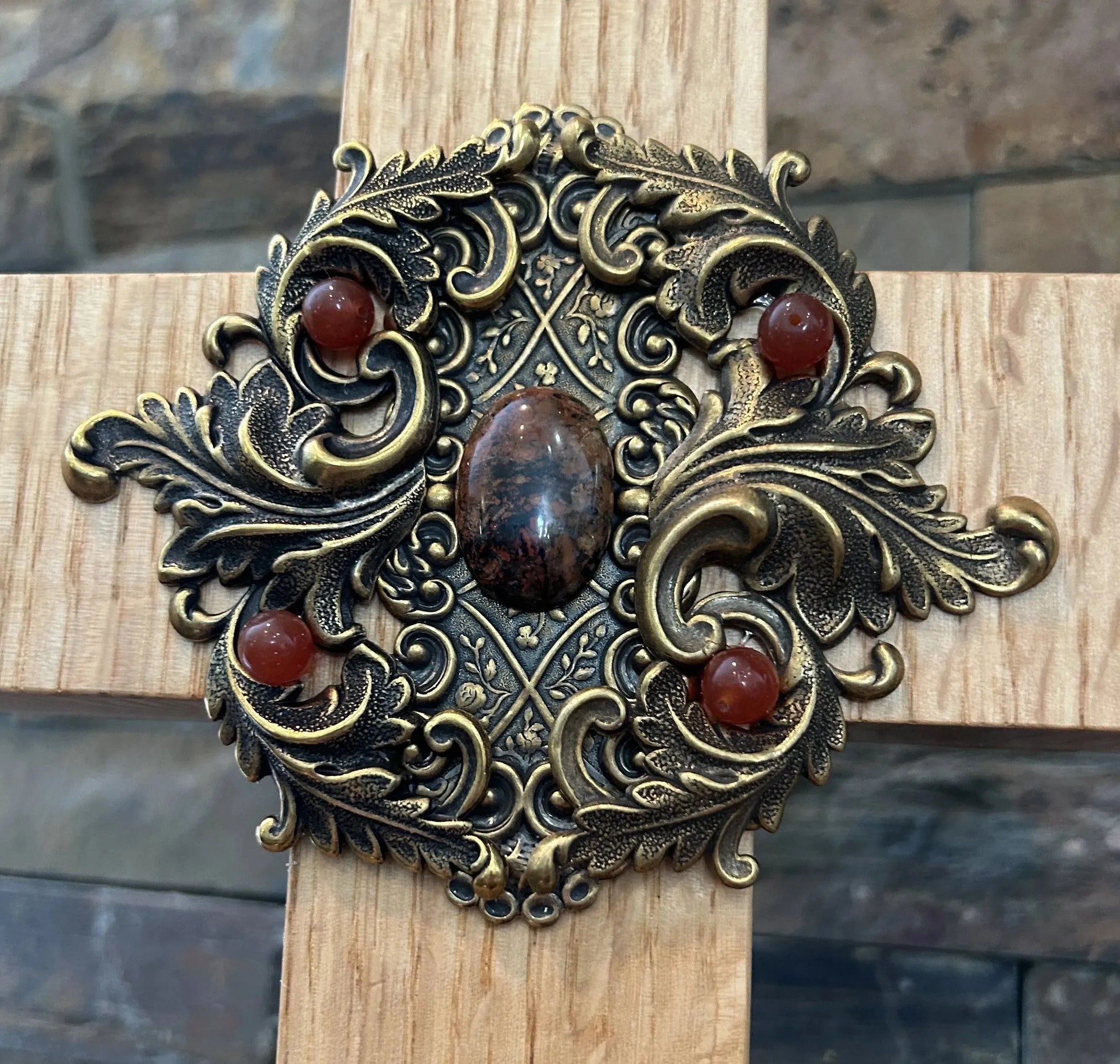Close-up of jeweled oak cross with ornate gold metal center and red gemstone accents