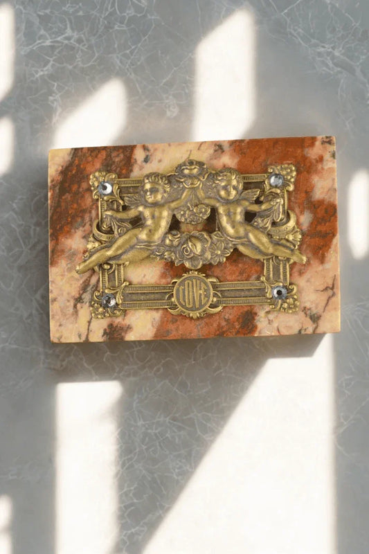 Handcrafted marble keepsake box with ornate gold cherubs and jeweled love emblem