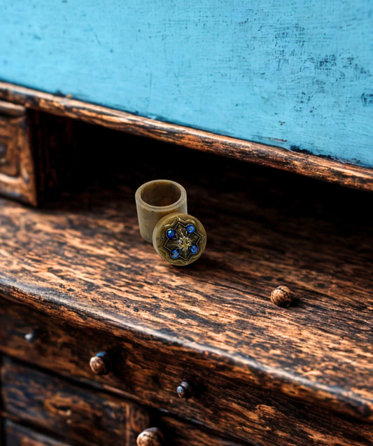 Jeweled fleur-de-lis trinket box open on rustic wooden surface
