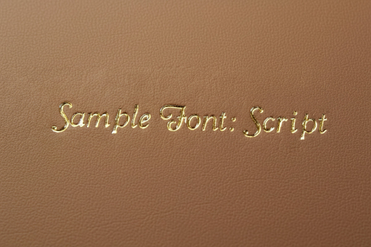 Gold script embroidery initials sample font on brown fabric background