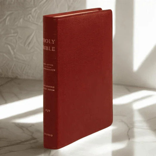 Red genuine leather KJV Holy Bible with gold spine text standing on marble surface