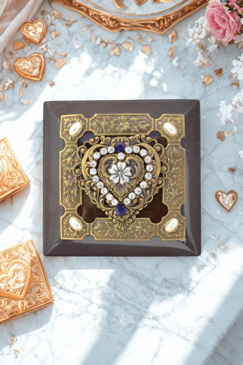 Purple heart wood keepsake box with ornate gold heart and jeweled decoration, top view on marble
