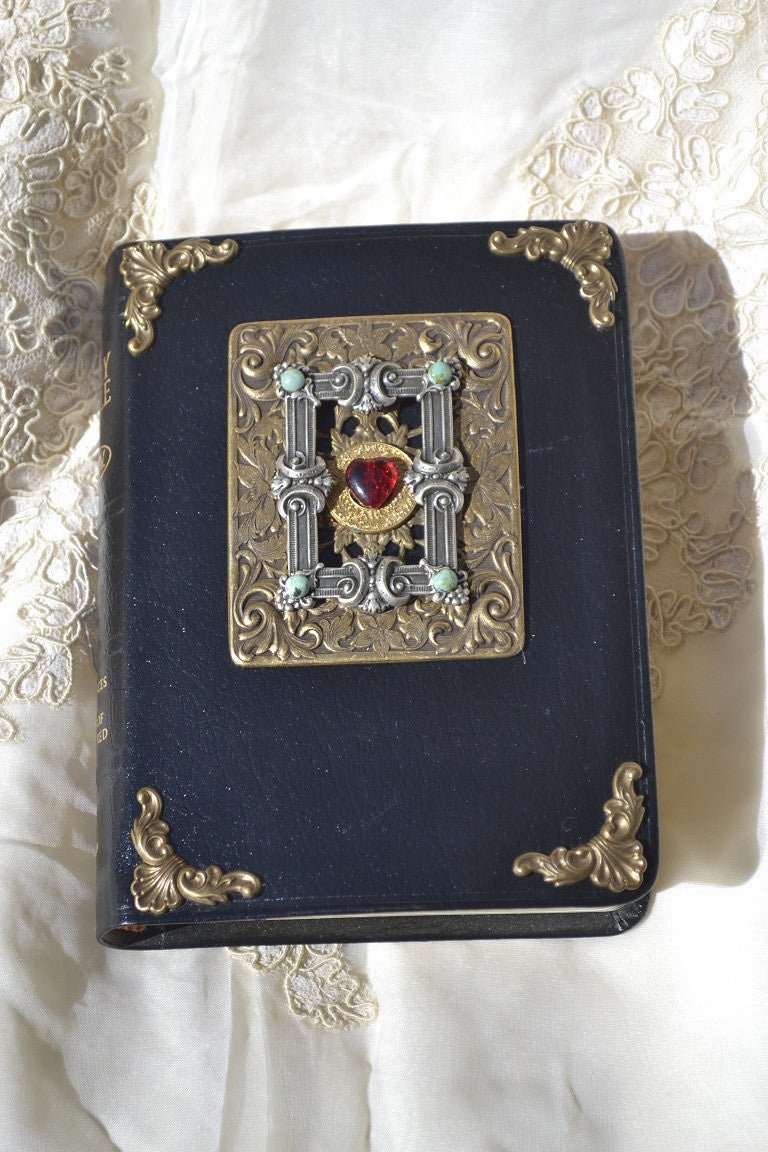 Antique jeweled Bible with ornate metalwork, black cover, and decorative gemstones