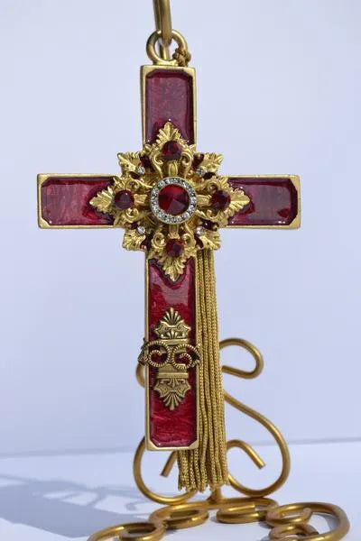 Vintage jeweled cross ornament with red gemstones, gold detailing, and a hanging tassel.