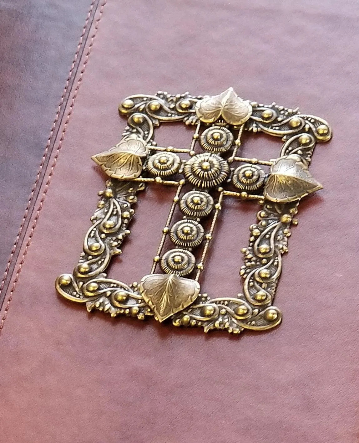 Closeup of ornate jeweled metallic cross embellishment on a giant print KJV Bible cover