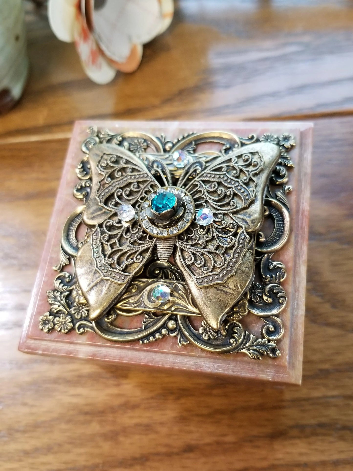 Jeweled butterfly soapstone box with ornate metal design and blue gemstone on lid