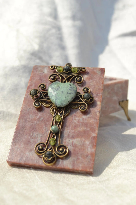 Handcrafted pink soapstone box with ornate jeweled cross and green heart gemstone lid