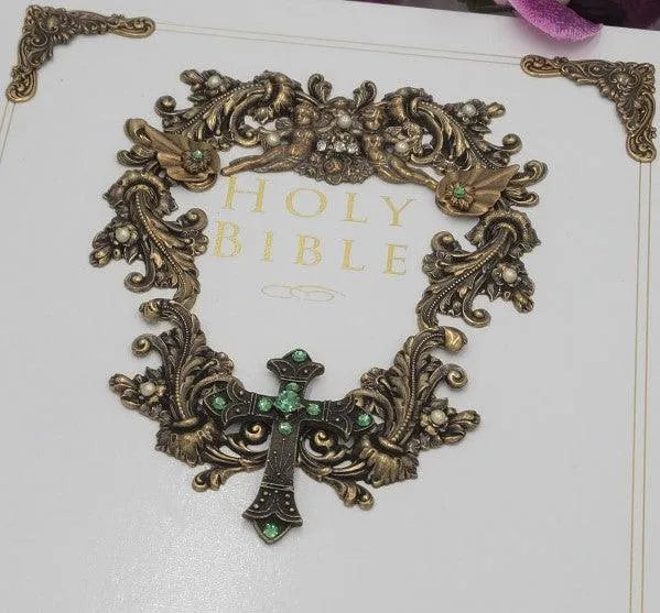 Jeweled family Bible with ornate gold cross and gemstones on decorative white cover