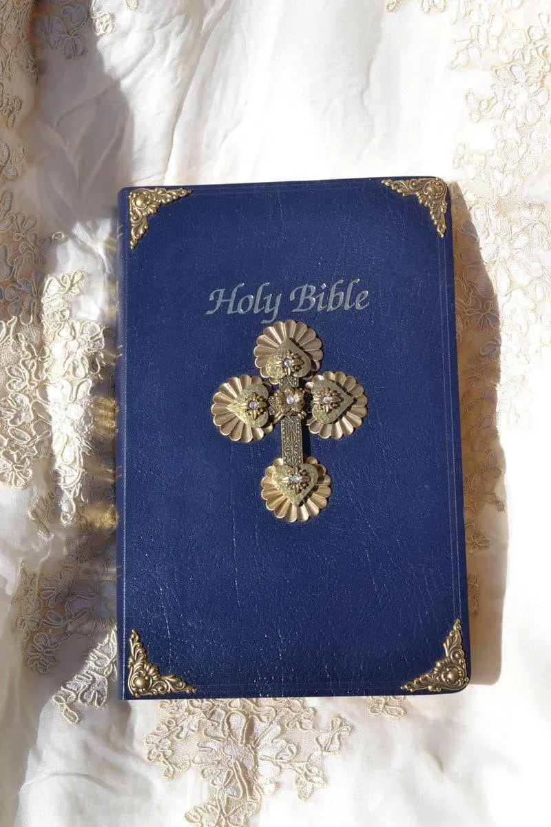 Blue Holy Bible with jeweled gold cross and ornate metal corners on embroidered fabric