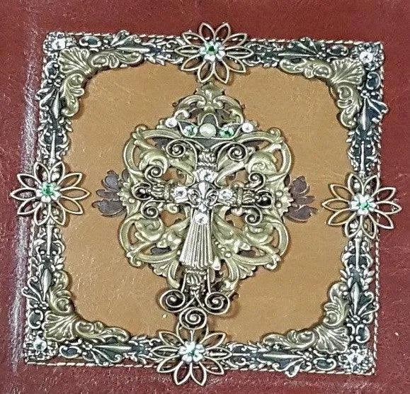 Jeweled Bible cover with ornate floral cross and rhinestone detail, close-up view