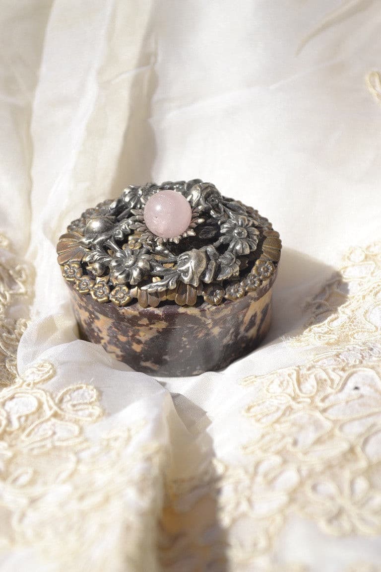 Jeweled soapstone keepsake box with floral metallic lid and pink gemstone accent