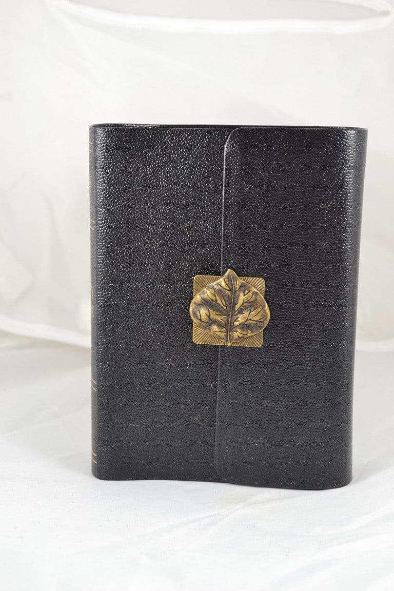Large print black leather Bible with gold leaf jeweled clasp on white background