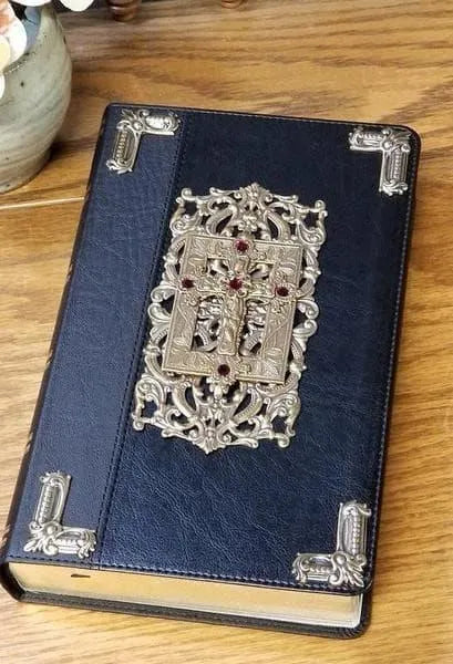 Ornate jeweled black KJV Bible with decorative metal accents on wood table